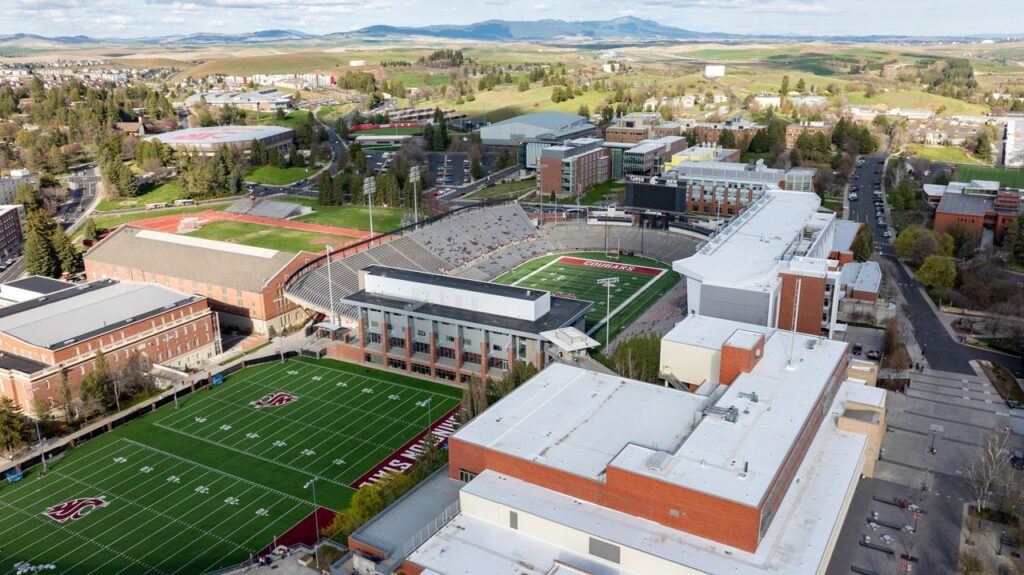 Drone shot of Washington State University campus featuring sports fields and buildings in Pullman, WA.
